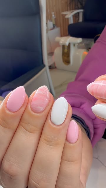 Pink and white almond nails with a marble accent by Foxy Nails and Spa